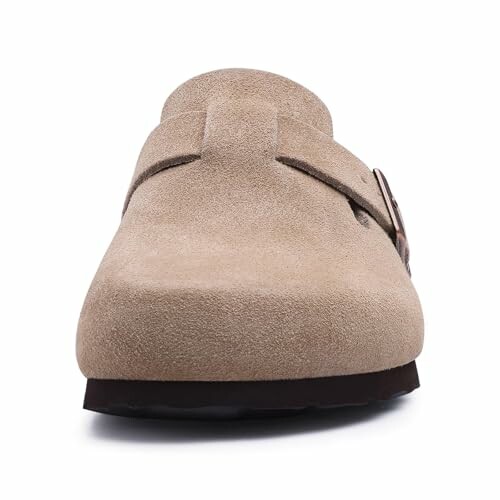 Front view of a beige suede clog with a buckle.